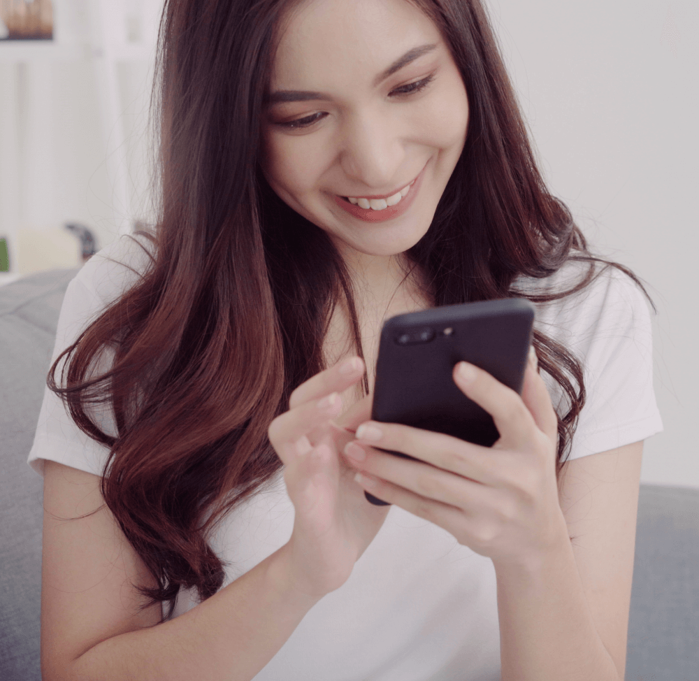 beautiful-asian-woman-using-smartphone-while-lying-couch-her-living-room (1)